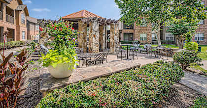 our apartments offer a courtyard with tables and chairs and plants at River Pointe, Texas, 77304