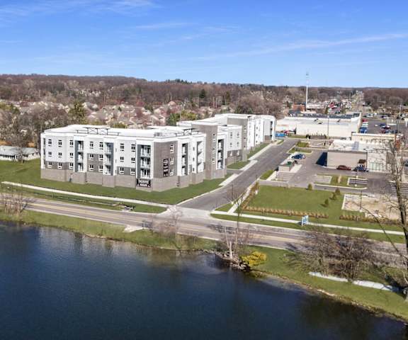 A large white building sits next to a body of water.