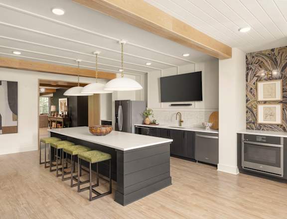A modern kitchen with a large island and stools.