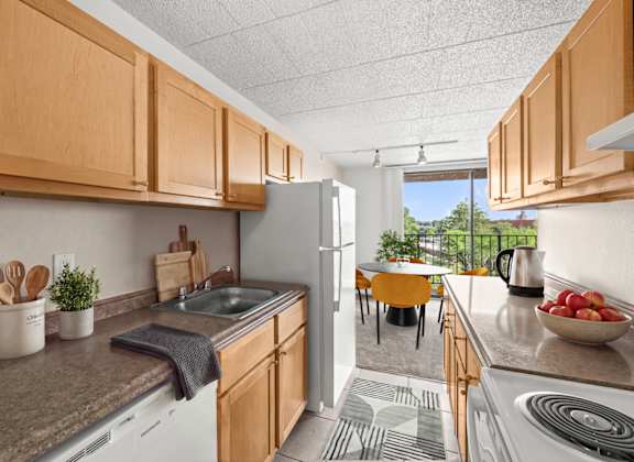 A kitchen with wooden cabinets and a white refrigerator.