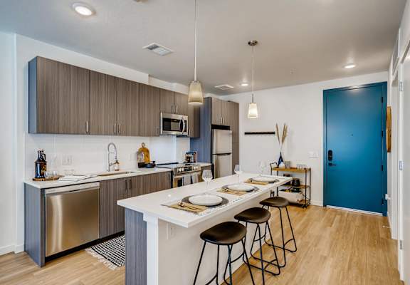 A kitchen with a white counter top and brown cabinets.