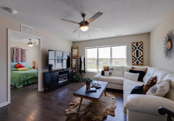 a living room with a couch and a ceiling fan