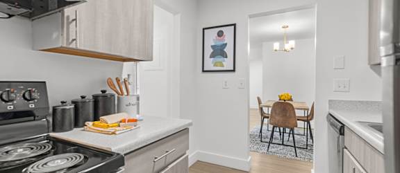 A modern kitchen with a stove, oven, and a dining table set for two.