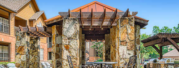 a patio with tables and chairs and a pergola at River Pointe, Texas, 77304