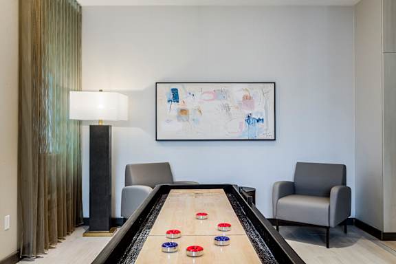 A room with a pool table and a painting on the wall.
