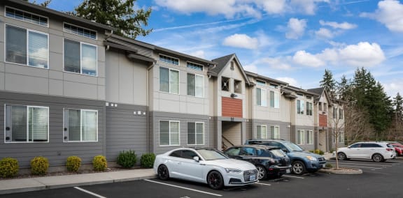 a row of apartment buildings with cars parked in front of them