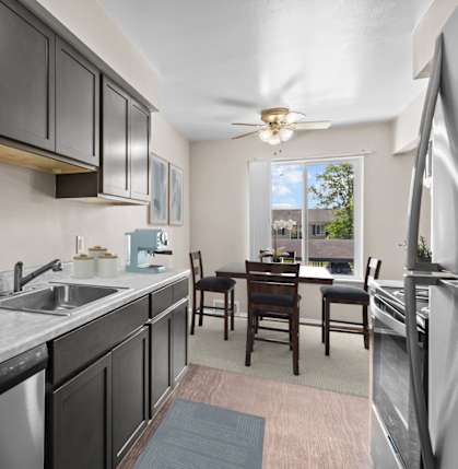 A kitchen with black cabinets and a marble countertop.