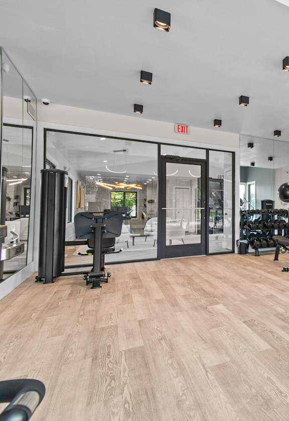 A gym with a treadmill and a mirror on the wall at Park On Canal Apartments - Clinton Twp, MI Apartments, Michigan