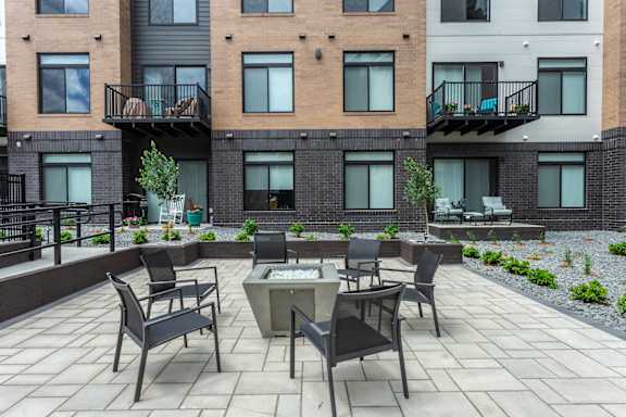 A patio with a table and chairs in front of a building.