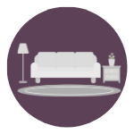 A white sofa sits next to a small table with a vase on it.