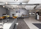 Thumbnail 8 of 8 - A modern office space with a grey stone wall and a long carpeted table.
