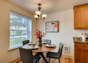 Thumbnail 6 of 34 - Apartments near Happy Valley for Rent - Sunnyside Village - Dining Room off of Kitchen with Large Window, White Walls, and Wood Flooring