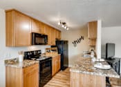Thumbnail 8 of 34 - Happy Valley, OR Apartments - Sunnyside Village - Spacious Kitchen With Granite Countertop, Dishwasher, Refrigerator, Microwave, and Wood Flooring