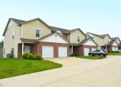 Thumbnail 3 of 22 - Cantwell crossing town homes exterior with single-car attached garage and driveway parking