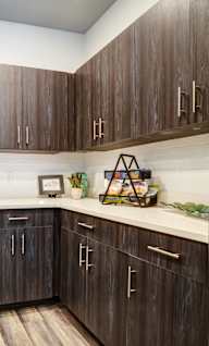 A modern kitchen with dark wood cabinets and stainless steel appliances.