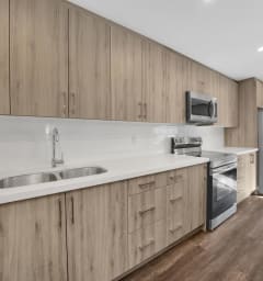 a kitchen with white countertops and wooden cabinets
