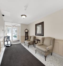 a living room with two chairs and a grandfather clock