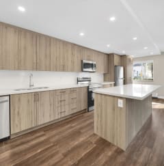 a kitchen with white countertops and wooden cabinets