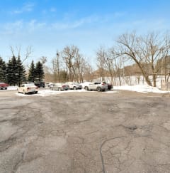 a parking lot in front of a building with snow on the ground