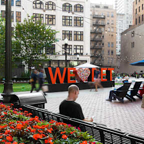 a man sitting on a bench in front of a building