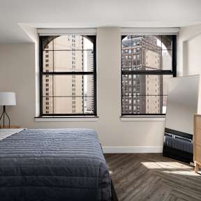 a bedroom with a bed and two windows