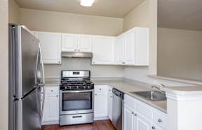 A kitchen with white cabinets and stainless steel appliances.