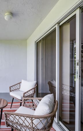 a living room with two chairs and a sliding glass door