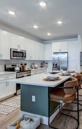 an open kitchen with a granite counter top and stools