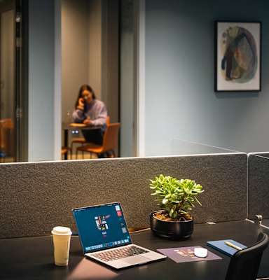 A laptop is open on a desk with a plant and a cup of coffee at Cherrywood Apartments, D18 VY3V, DUBLIN 18