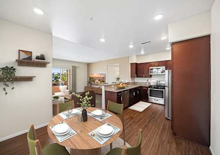 A modern kitchen with a dining table set for two.
