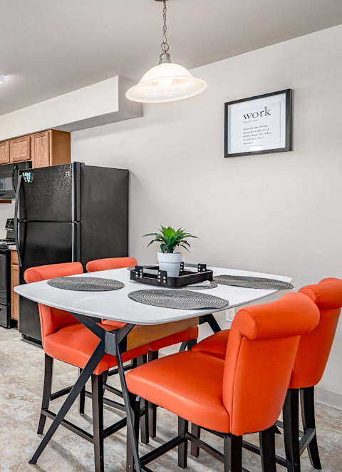 A kitchen with a table and chairs.