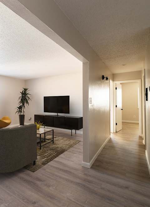 A living room with a grey couch and a wooden table.