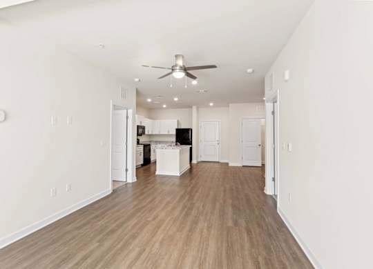 Peaks of Lexington Apartments Kitchen with Black Appliances, Granite Countertops and White Cabinetry and connected living room