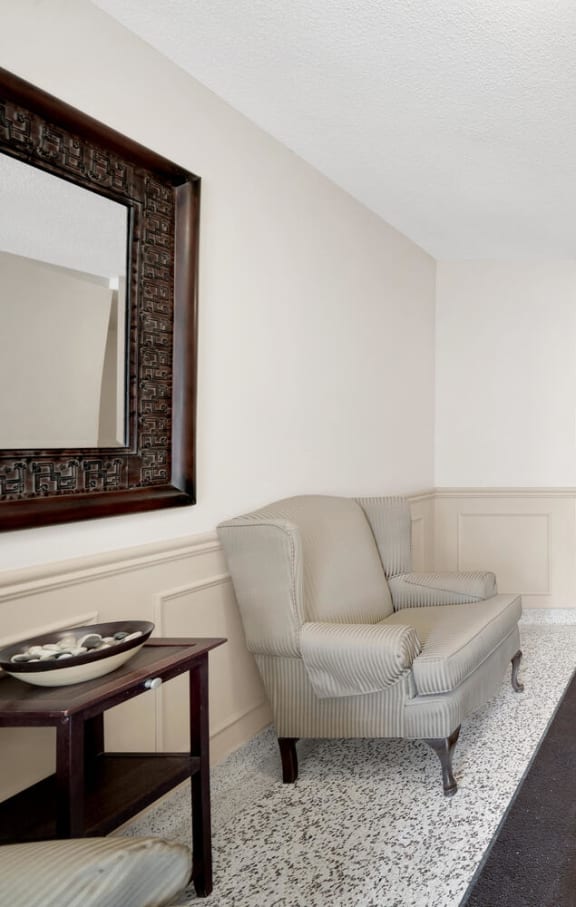 a living room with white walls and a dark rug