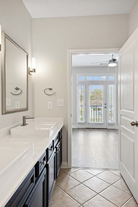 A spacious room with a mirror, exercise equipment, and a television displaying a sunset.