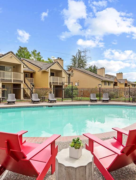 A poolside area with red chairs and a hot tub at MonteVista Apartments, Beaverton, OR