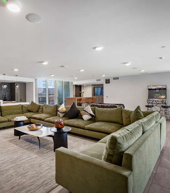 Fusion Hollywood clubhouse with large green couches and a kitchen island