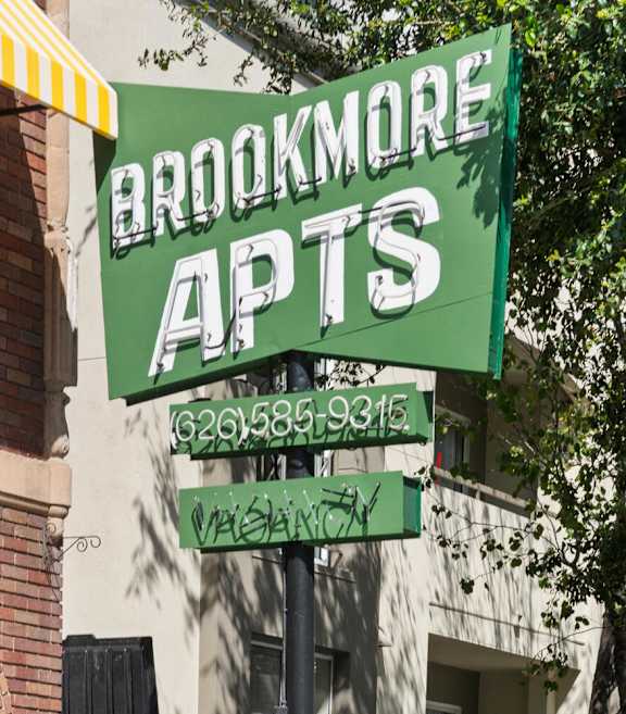 A monument sign that reads "Brookmore Apts" in Pasadena, CA