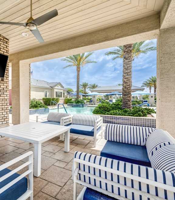 A patio with a white couch, a fireplace, and a television.