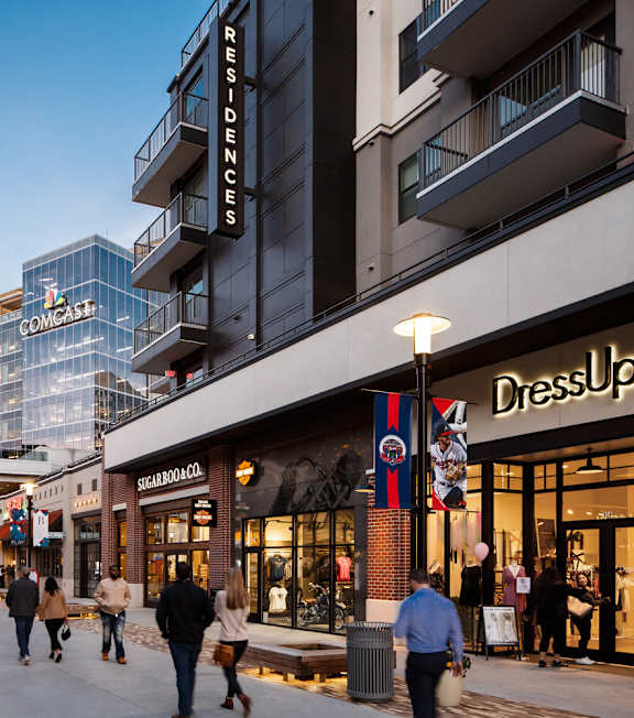 A street view of a shopping area with people walking and stores like DressUp and COMMAND  grass at Georgian Oaks Apartments in GA, 30080