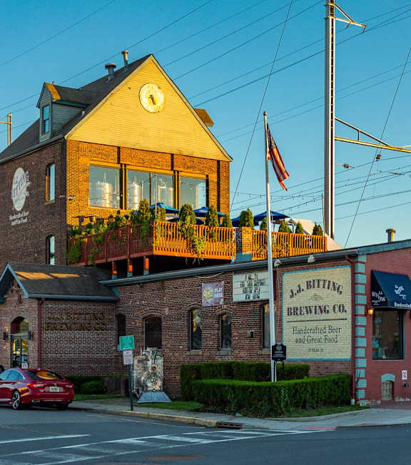 A building with a clock tower and a sign that says "J.R. RITTING BREWING CO." is in the foreground.