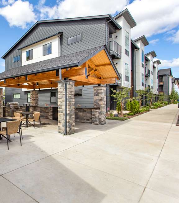 A patio with a table and chairs is in front of a building.