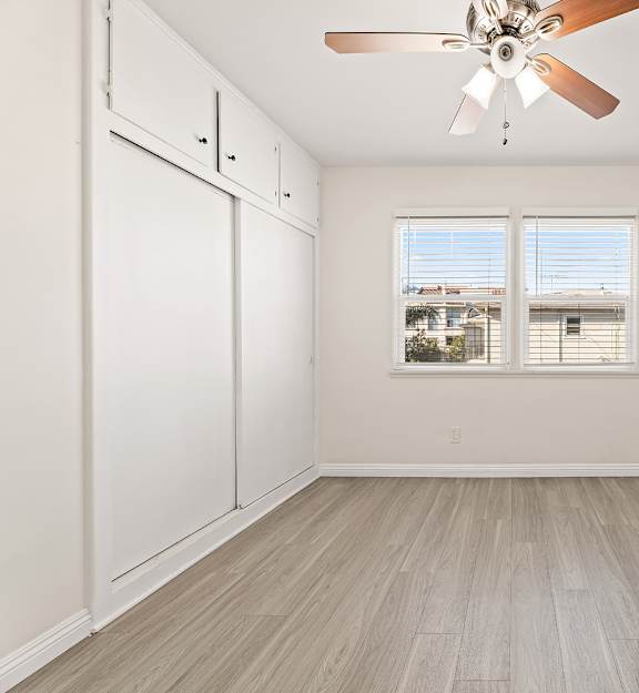 A room with a ceiling fan and a window.