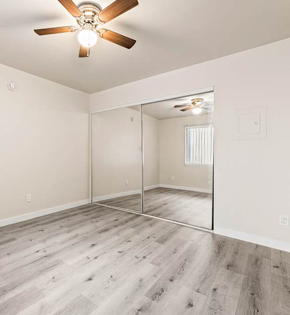 A room with a ceiling fan and a sliding glass door.