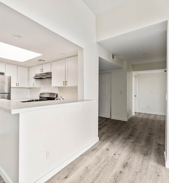 A kitchen with white cabinets and a white island.