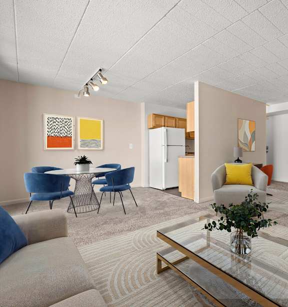 A living room with a glass coffee table and blue chairs.