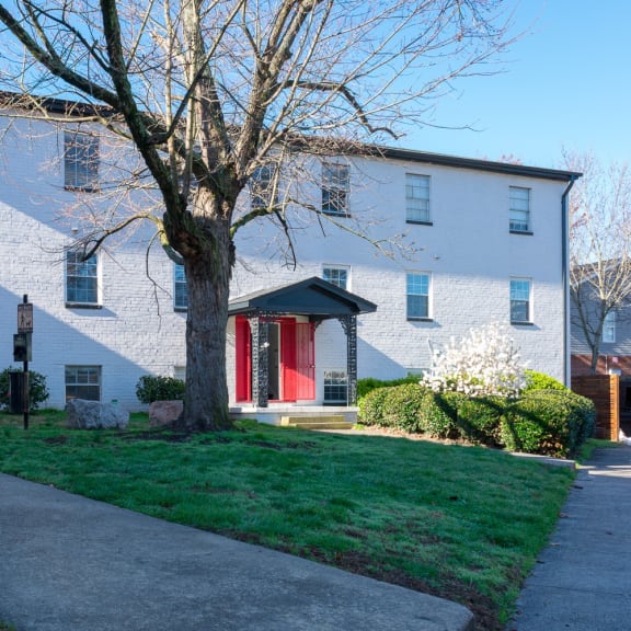 a white house with a tree in front of it at Viceroy Apartments, Durham , North Carolina