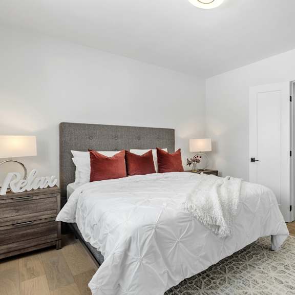 A bedroom with a large bed and a headboard that says "Relax".
