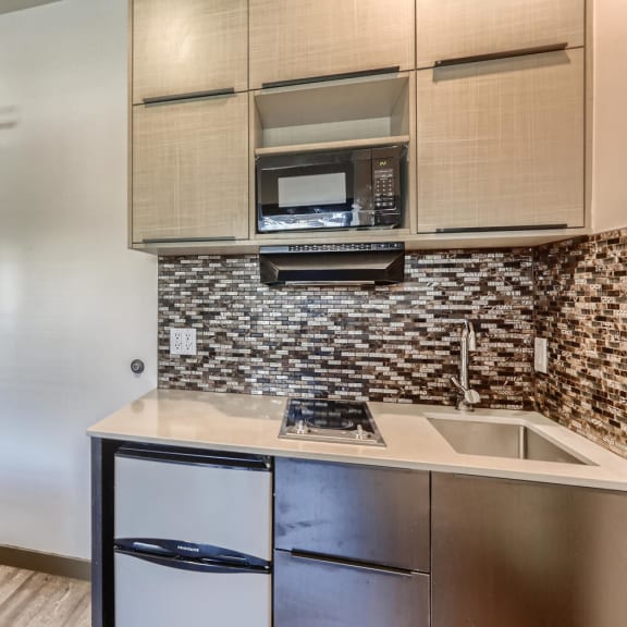 a small kitchen with a sink and a refrigerator at Mikado Little Tokyo, Los Angeles