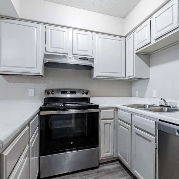 a kitchen with wooden cabinets and a stove and a sink at Diamond Ridge Apartments, Oklahoma City, OK, 73114
